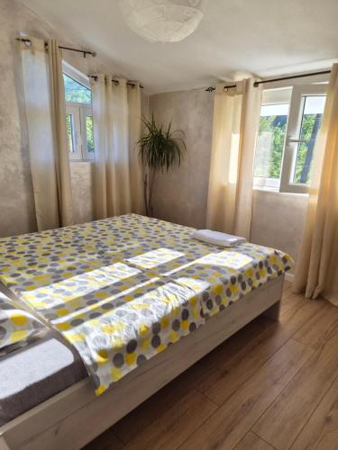 a bedroom with a bed with a yellow and white comforter at Sunny Valley Retreat near Skadar Lake in Virpazar