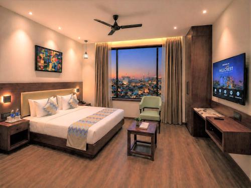 a hotel room with a bed and a large window at Hillcrest Hotel & Resort, Abu Road in Ābu Road
