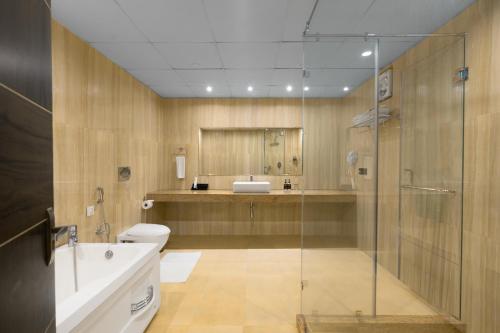 a bathroom with a shower and a toilet and a sink at Span inn & Suites by Alivaa, Manali in Baragrān