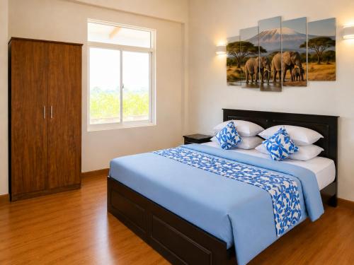 a bedroom with a large bed with blue and white pillows at Bundala Forest Resort Yala in Weerawila