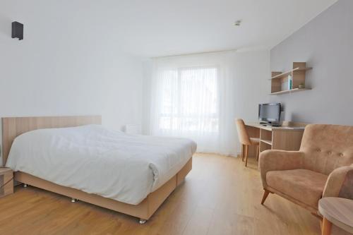 a bedroom with a bed and a desk and a chair at KOSY Appart'Hôtels - La Maison Des Chercheurs in Vandoeuvre-lès-Nancy