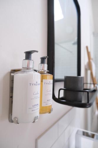 a bathroom counter with two bottles of soap and a mirror at The Chequers at Burcot in Oxford
