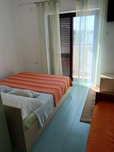 a bedroom with a bed and a large window at Apartments Marica in Trogir
