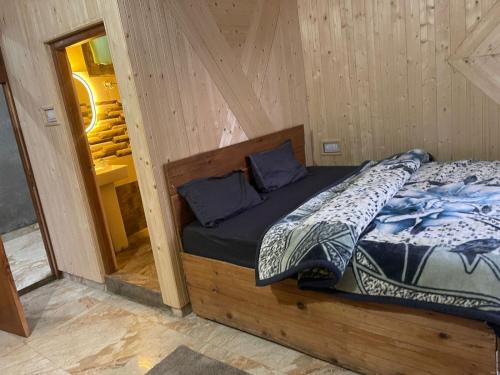 a bed in a wooden room with a mirror at Infinity Snowline , Kalga in Kalgha