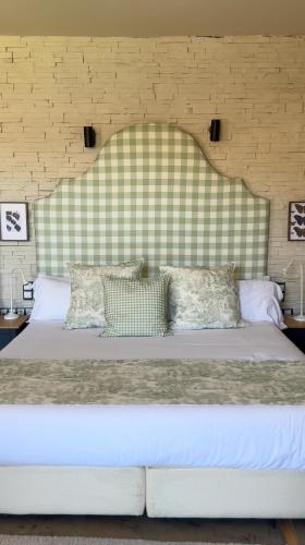 a bedroom with a large bed with a large headboard at Maison Conde de la Cebada in Ampudia