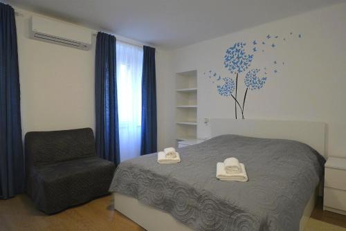 a bedroom with a bed and a chair at Apartments and Rooms Oliva in Cres