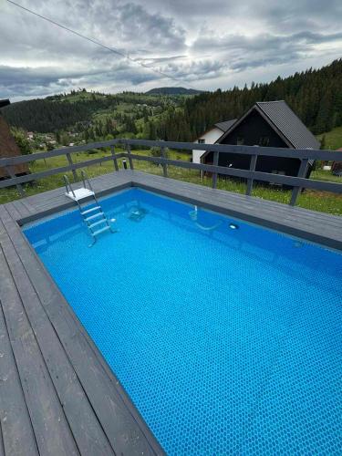 a swimming pool on top of a wooden deck at Котедж HOLIDAY HOUSE in Yablunytsya