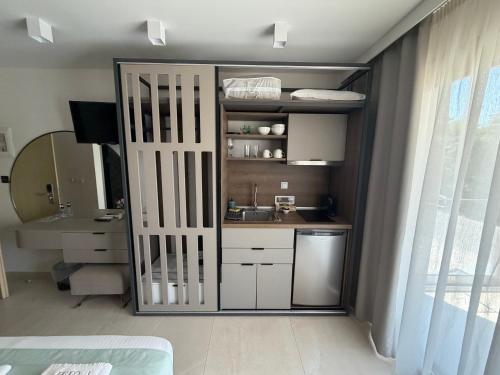 a kitchen with a sliding door with a sink at Elegant Corner Superior Rooms & Apartments in Limenaria