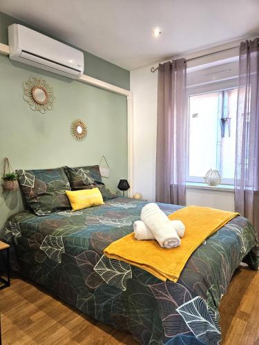a bedroom with a bed with a blanket and a fan at Cosy room - centre ville - 2 pers in Sarreguemines
