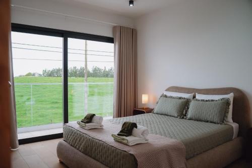 a bedroom with a bed and a large window at Terrassi Villa in Angra do Heroísmo