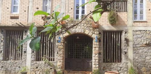 a stone building with a gate and a door at Cottage by Ranmuduella in Labugama