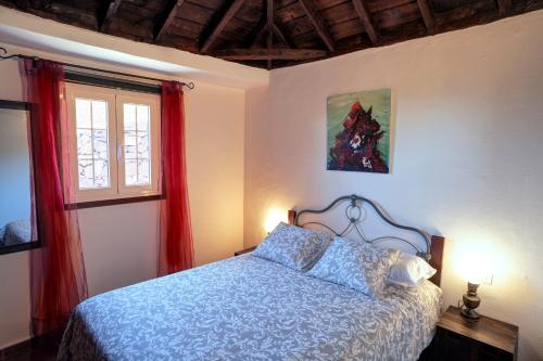 a bedroom with a bed and a window with red curtains at Sabina in Mazo