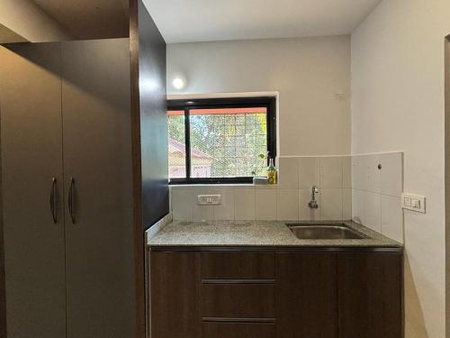 a small kitchen with a sink and a window at UnigoOne Apartments, BH, Palolem in Canacona