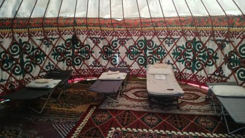 a room with chairs and tables and a wall at Актан yurt cemp in Chong-Kyzylsu
