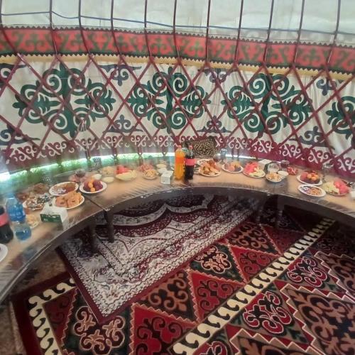 a table with plates of food on a wall at Актан yurt cemp in Chong-Kyzylsu