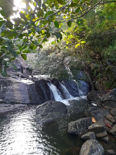 a waterfall on a river with rocks and trees at Cottage by Ranmuduella in Labugama