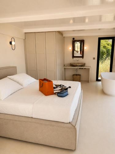 a bedroom with a large bed with an orange bag on it at THE HILL Suite in Ialysos