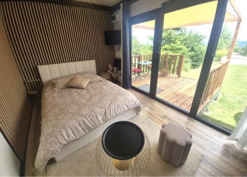a bedroom with a bed and a balcony with a patio at Douce Escale in Vichel