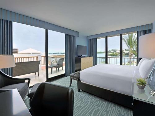 a hotel room with a bed and a balcony at Hamilton Princess & Beach Club A Fairmont Managed Hotel in Hamilton