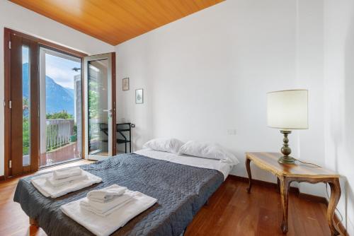 a bedroom with a bed with a table and a window at Villa Ulrica in Nago-Torbole