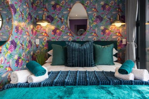a bedroom with a large bed with a floral wallpaper at Crossfire @ Home in Somerset West