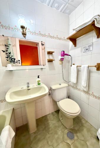 a bathroom with a toilet and a sink at Hostal Los Arcos Vejer in Vejer de la Frontera