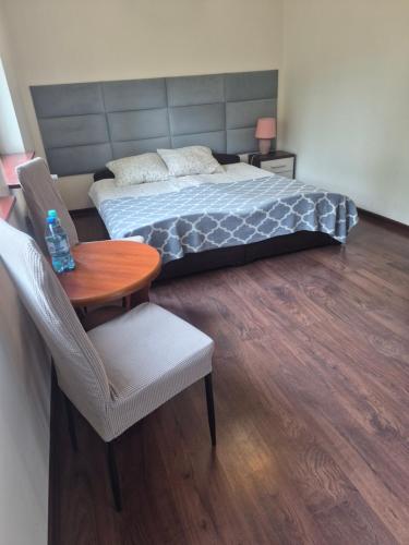 a bedroom with a bed and a table and chair at Srebrny Świerk in Wambierzyce