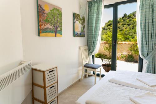 a bedroom with a bed and a chair and a window at Apartmani Natal in Donja Lastva