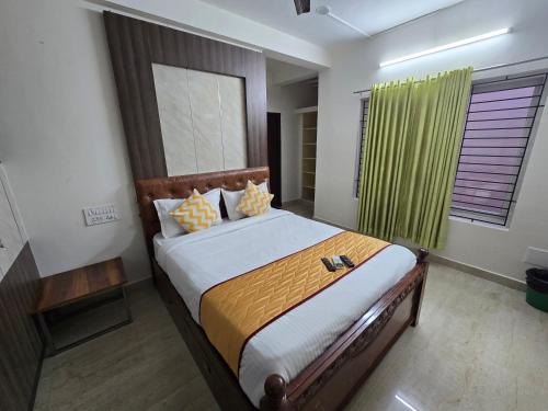 a bedroom with a large bed with a green curtain at GT Homestay in Chennai