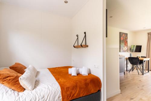 a bedroom with a bed with two towels at Tiny House with decking | 2 persons in Gasselte