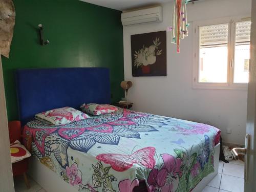 a bedroom with a bed in a green wall at Maison MATIASMA avec Jacuzzi in Hyères