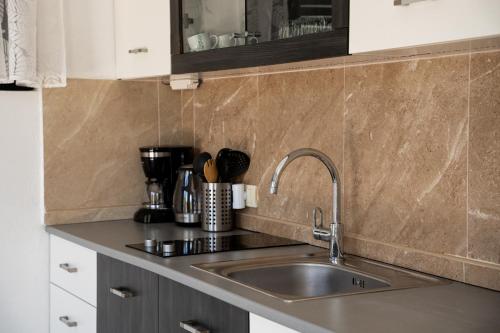 a kitchen with a sink and a counter top at Apartmani Natal in Donja Lastva