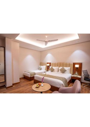 a hotel room with two beds and a table at Hotel Raaj Palace in Agra