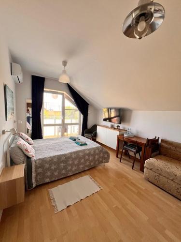 a bedroom with a bed and a desk and a window at Villa NOVA Dębki in Dębki