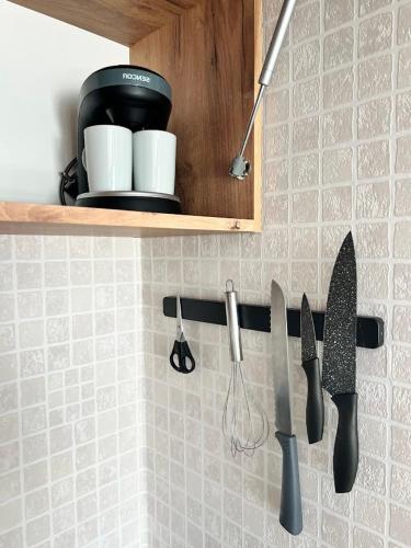 a kitchen counter with knives on a wall at Villa NOVA Dębki in Dębki