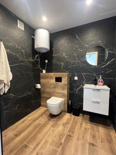a bathroom with a toilet and a black wall at Marta in Carini