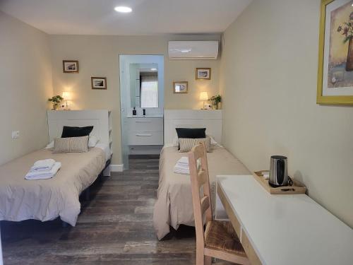 a room with two beds and a table in it at Bronlara in Alhaurín de la Torre