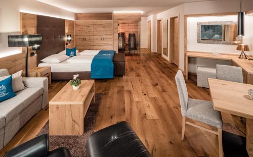 a hotel room with a bed and a couch at Hotel Saltauserhof in Saltusio