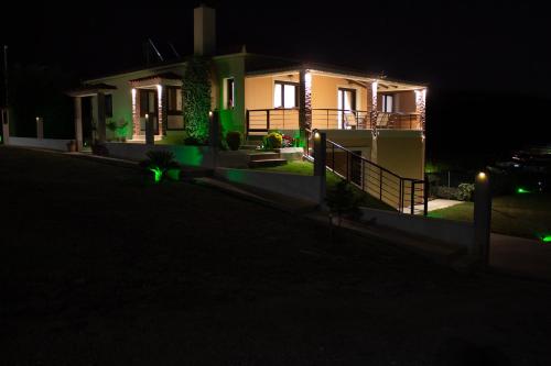 a house lit up at night with green lights at Hilltop House Dikella in Alexandroupoli
