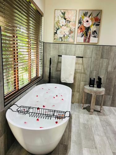 a bathroom with a white bath tub with flowers on it at Rio Vista Lodge in Malelane