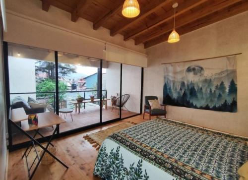 a bedroom with a bed and a large window at Casa Colibri San Cristobal in San Cristóbal de Las Casas