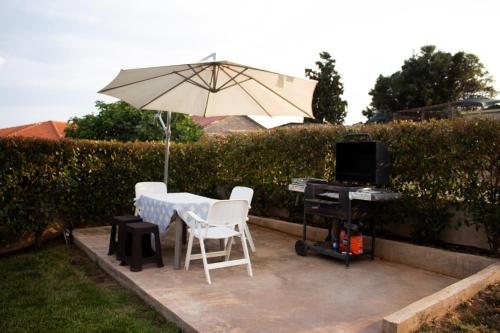 a table and chairs with an umbrella and a keyboard at Hilltop House Dikella in Alexandroupoli