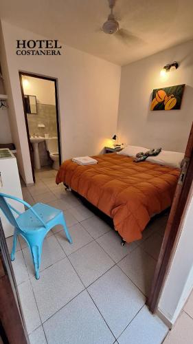 a hotel room with a bed and a blue chair at HOTEL COSTANERA - Mejor Ubicacion en FORMOSA in Formosa