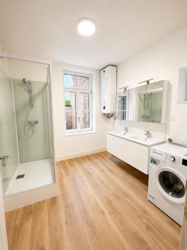 a large bathroom with a shower and a washing machine at Maison hypocentre de Bethune in Béthune
