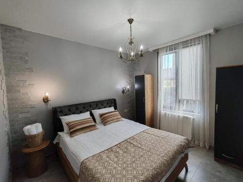 a bedroom with a large bed and a chandelier at Vakho house - first floor in Urekis Sadguri