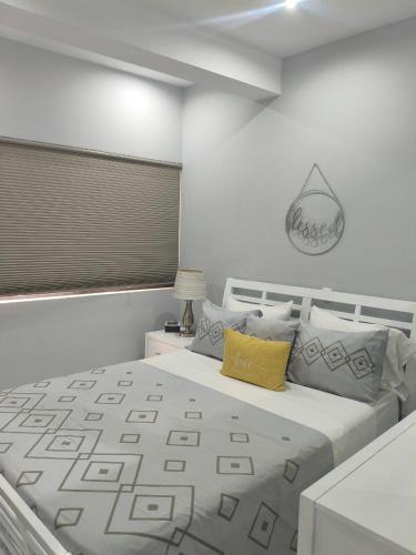 a bedroom with a white bed with a yellow pillow at Cantinho de Mindelo in Mindelo