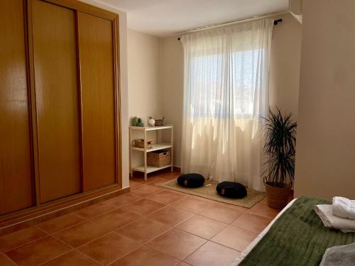 a bedroom with a window with two cats laying on the floor at Duna Blanca House - Piscina privada - 450m de la playa in Daimuz