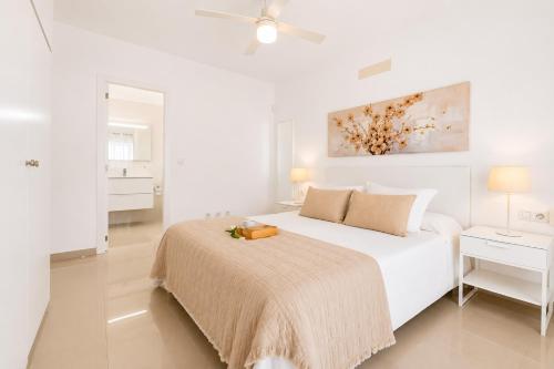 a white bedroom with a bed and a ceiling fan at CHALET 83 con PISCINA PRIVADA in Callao Salvaje