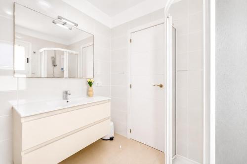 a white bathroom with a sink and a shower at CHALET 83 con PISCINA PRIVADA in Callao Salvaje