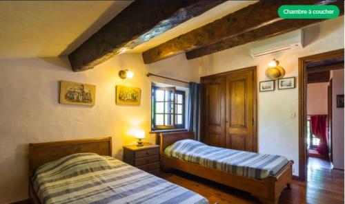 a bedroom with two beds and a window at Le mas du goïo in Seillans